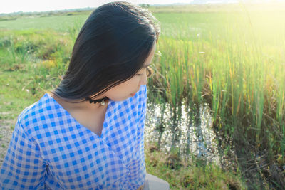 Close-up of young woman standing at rice paddy