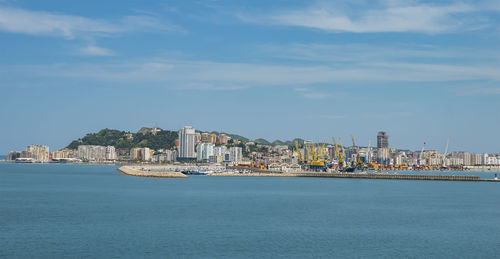 View of buildings by sea against sky