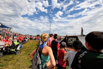 Rear view of people standing on road against sky