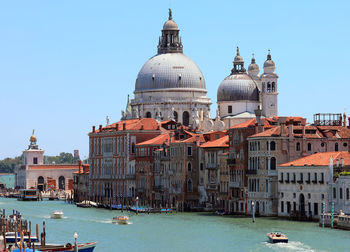 Canal amidst buildings against sky