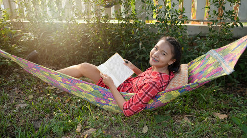 Smiling young woman lying on hammock