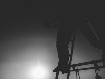 Low section of silhouette woman standing against clear sky