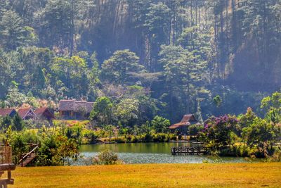 Scenic view of village by lake against mountain