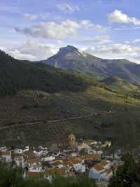 Scenic view of townscape by mountains against sky