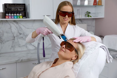 Midsection of female dentist examining patient in clinic