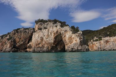 Rock formations by sea against sky