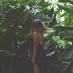 Rear view of woman standing by tree