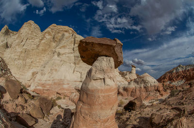 Rock formations on mountain against cloudy sky