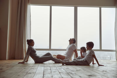 Side view of couple sitting on floor at home