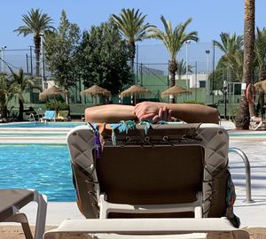 People sitting on chair by swimming pool