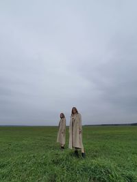 Woman standing on field against sky