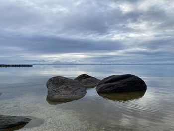 Rocks in sea against sky