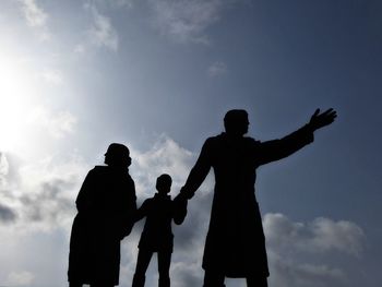 Silhouette friends standing against sky