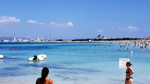 People on beach by sea against sky