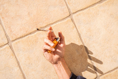 Hand of man holding cigarette and lighter