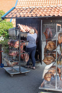 Rear view of woman standing for sale at market stall