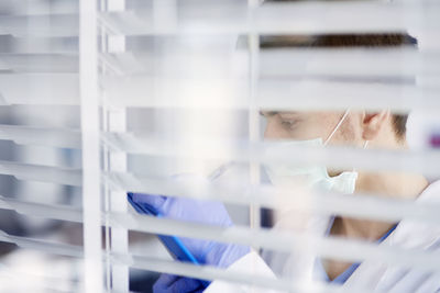 Portrait of man seen through glass window