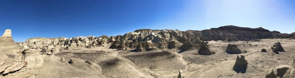 Panoramic view of rocky mountains against clear blue sky