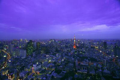 Tokyo tower with cityscape against sky at dusk