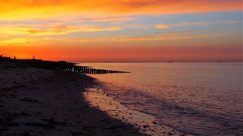 Scenic view of sea against orange sky