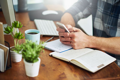 Midsection of businessman working on table