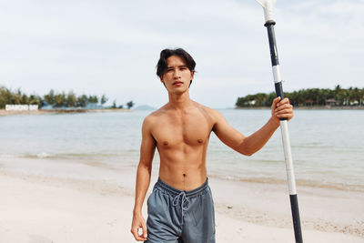 Portrait of young man standing at beach