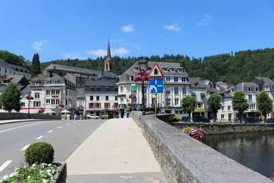 View of buildings by canal against blue sky