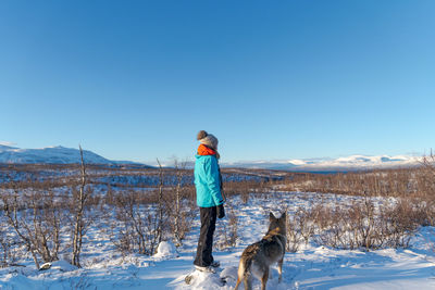 Woman with dog on snow