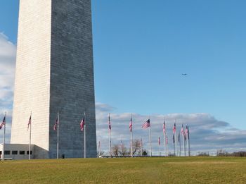 American flags surrounding washington monument against sky