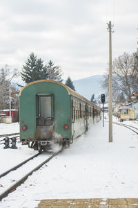 Train on railroad tracks against sky during winter