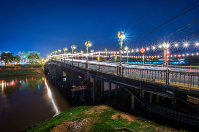 Illuminated bridge against sky at night