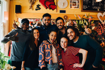 Portrait of cheerful young multi-ethnic friends while standing in restaurant during brunch