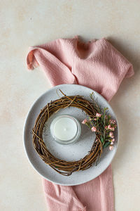 Plate with decorative wreath made of twigs, flowers and candle. wedding or spring table setting.