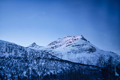 Scenic view of snowcapped mountains against clear blue sky