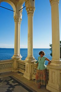 Portrait of woman standing by railing against sea