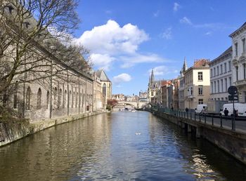 Canal amidst buildings in city against sky