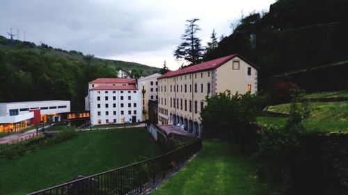 View of train by buildings against sky