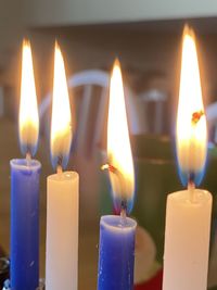 Close-up of lit candles burning in temple