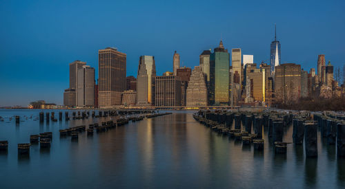 Buildings at waterfront against blue sky