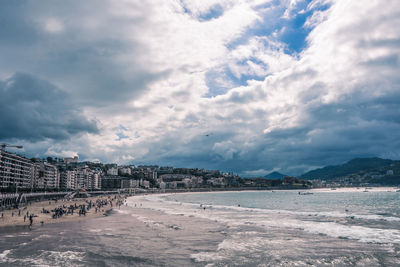 Buildings in city against cloudy sky