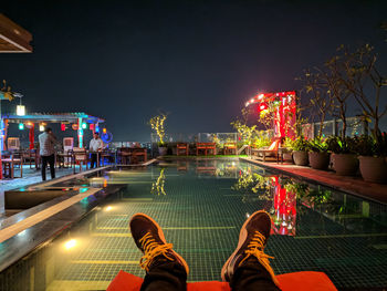 Low section of people in illuminated city at night