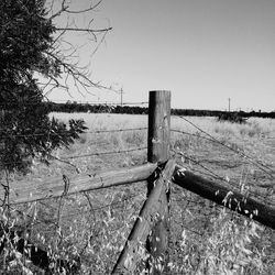 Wooden posts on field against clear sky