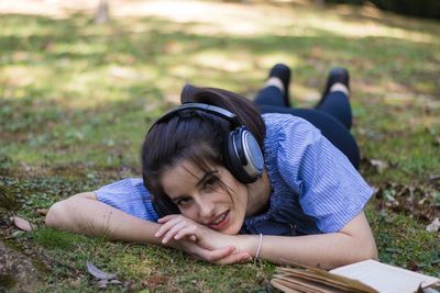 Portrait of young woman lying on land