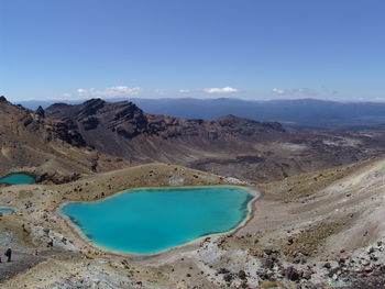 Scenic view of lake and mountains against blue sky