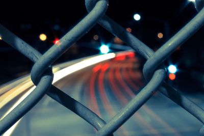 Close-up of chainlink fence at night