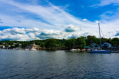 Sailboats in sea against buildings in city