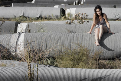 Full length of woman sitting on rolled grass outdoor, staduim