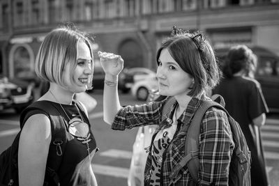 Female friends standing on road in city