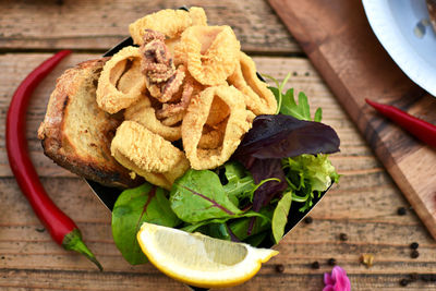 Close-up of bread and fried calamari in bowl on table