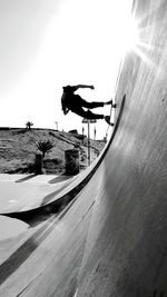 Man skateboarding on street against clear sky